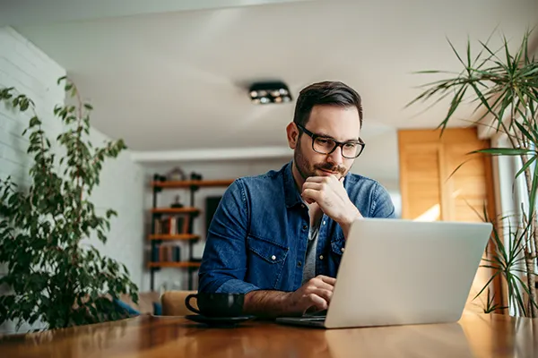 Man reading wealth insights on laptop
