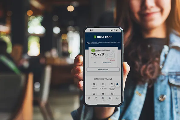 student holding up phone with online banking app